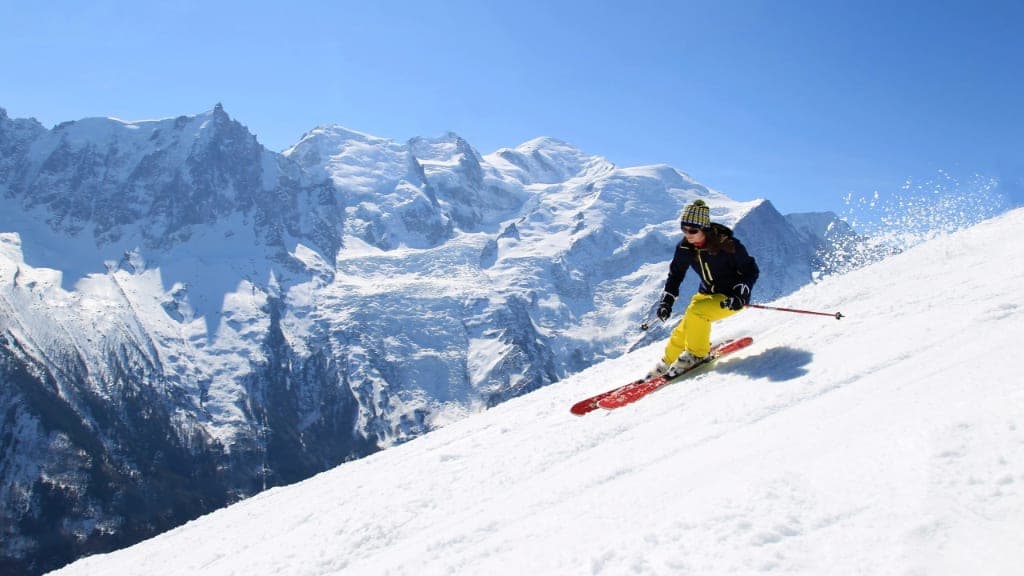 An alpine skier carving below the Mont Blanc massif